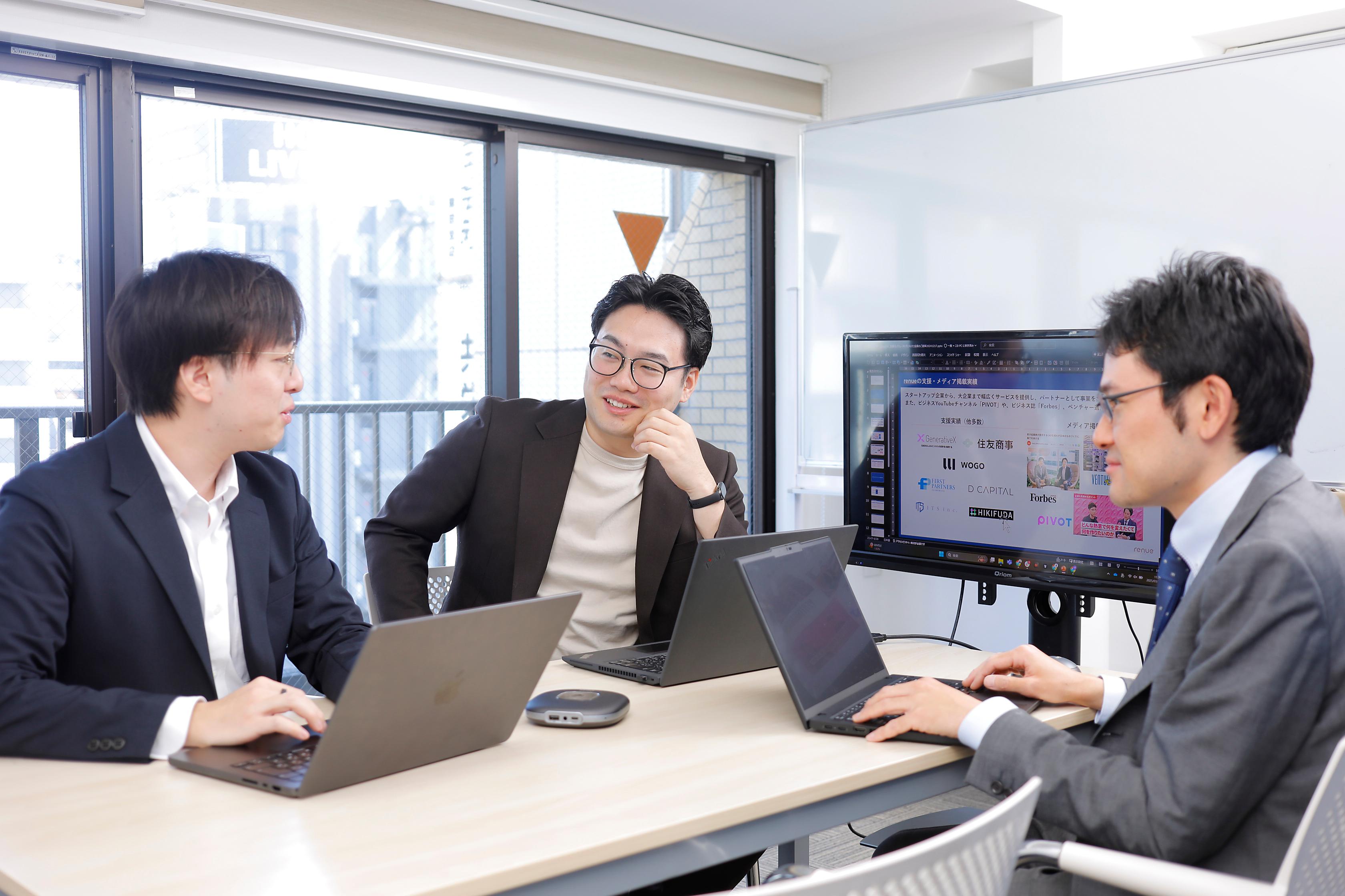 PCを囲んで業務について議論するrenueメンバー